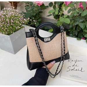 Détail d'un sac seau tissé avec garniture en cuir noir et fermoir tournant argenté