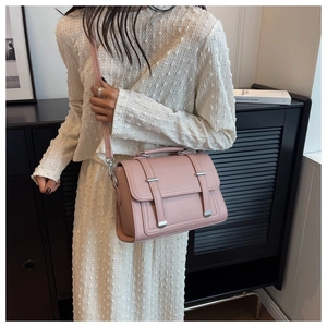 Close-up of pink square crossbody bag with textured leather and silver hardware details