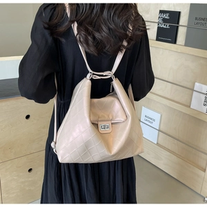 Détail du sac cabas matelassé beige avec fermoir rotatif argenté sur le dos