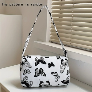 Detail of canvas armpit bag with random butterfly patterns and zip closure on windowsill