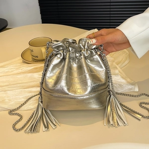 Sac seau métallisé argenté avec franges et bandoulière chaîne sur fond blanc