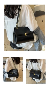 Detail of black leather underarm bag with gold metal buckle and chain strap shown on model