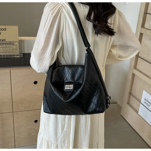 Détail du sac à bandoulière en cuir matelassé noir avec fermoir rotatif argenté