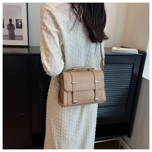 Detail of khaki crossbody bag with matte lychee texture and silver metal accents