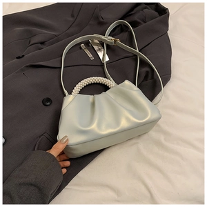 Dettaglio borsa a nuvola increspata verde menta con manico di perle su blazer