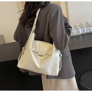 Détail du sac cabas matelassé blanc cassé avec un fermoir rotatif métallique chic
