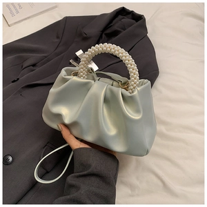Dettaglio borsa cloud verde chiaro perlato con manico di perle di lusso e pieghe morbide