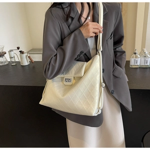 Détail du sac fourre-tout matelassé blanc crème avec fermoir rotatif argenté élégant