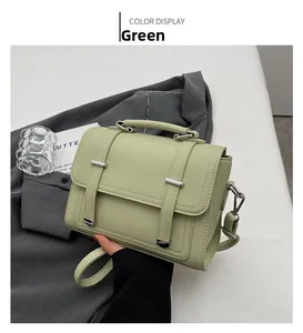 Detail showing mint green lychee pattern leather texture and silver buckle on square bag