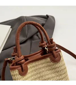 Close-up of durable leather handles and woven texture on a straw bucket bag
