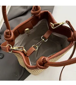 Detailed top view of straw bucket bag showing gold hardware and inner zipper pocket