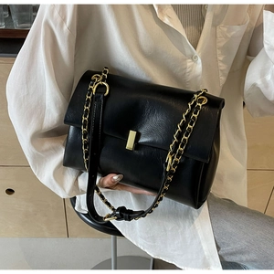 Detail showing high-quality black faux leather texture and elegant gold metal clasp