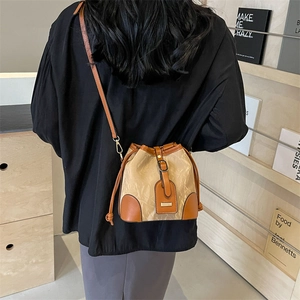 Minimalistische Beuteltasche aus beigem Stoff und braunem Leder mit Schulterriemen