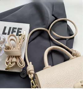 Vue détaillée du sac selle en cuir grainé beige avec doubles anses et bandoulière