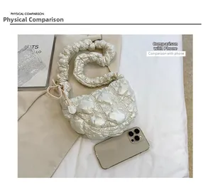 Detail view of white puffy cloud bag showing size comparison with a smartphone