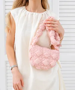 Model wearing a pink quilted bubble bag featuring unique diamond puff texture and soft strap