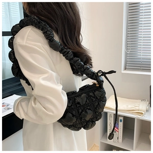 Detail of black quilted cloud bag with pleated bubble texture and tie strap design