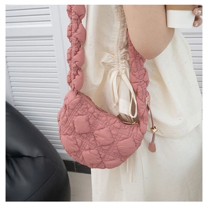 Detail of pink quilted puffer bag showing ruched shoulder strap and soft texture