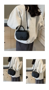 Détail du sac selle en cuir grainé noir avec boucle design et bandoulière amovible