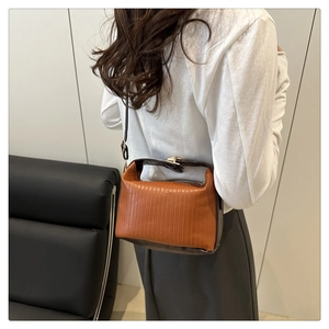 Detail of vintage-style orange and brown pleated handbag with vertical stripe embossing