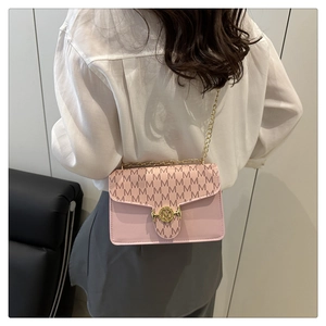 Detailed view of pink crossbody bag with chain strap and gold M-logo lock on the flap