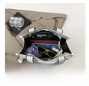 Spacious interior of white monogram tote bag with wide strap holding daily essentials