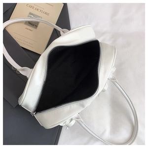 Top view of white canvas tote bag with black fabric lining and silver metal zipper