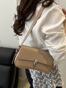 Minimalist beige underarm bag in matte leather with silver buckle and shoulder strap