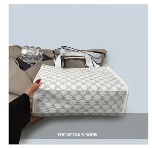Detail showing the reinforced wear-resistant base of a white monogram tote bag