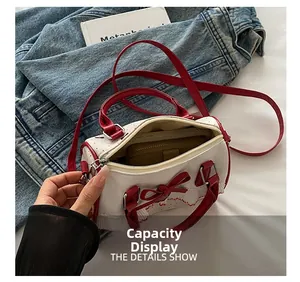 Detail showing inner capacity of white bow handbag with red handles and lace trim