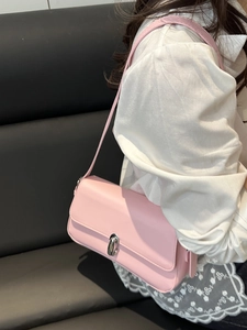Pink leather underarm bag for women with silver metal twist lock in a minimalist style
