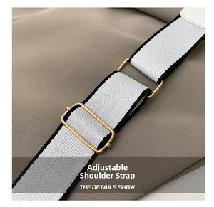 Close-up of adjustable black and white striped woven strap with premium gold metal buckle