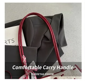 Detail of red PU leather handle with decorative polka dot bow on the white tote bag