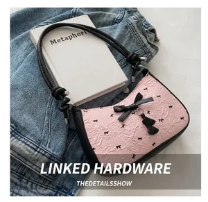 Detailed view of pink seersucker fabric with black bows and metal strap connectors
