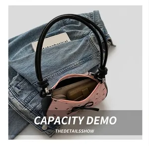 Top view of pink bow baguette bag interior showing capacity for phone and long wallet