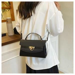 Dettaglio borsa a mano nera con trama trapuntata ed elegante chiusura dorata