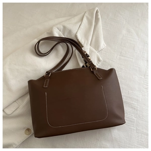 Detail of brown faux leather tote bag with white stitching and decorative silk scarf