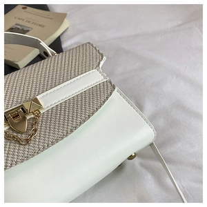 Detailed close-up of white leather and khaki woven texture with a gold metal lock