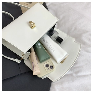 Internal view of minimalist white handbag showing capacity for phone and cosmetics