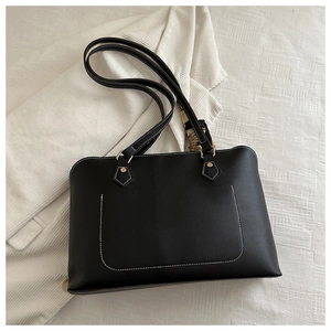 Detail of black PU tote bag with white contrast stitching and decorative silk scarf