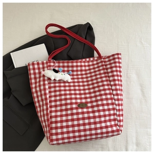Détail du sac cabas à carreaux rouges et blancs avec logo fait main et breloque chien peluche