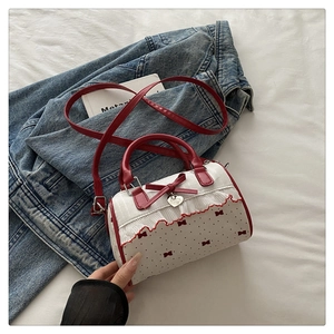 Detailansicht der Handtasche mit roten Punkten und Rüschen auf blauer Jeansjacke