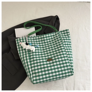 Détail du sac cabas à carreaux vert et blanc avec patch en cuir et pendentif chien peluche