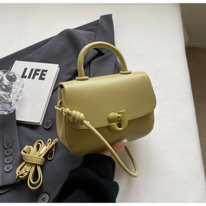 Détail du sac selle vert avocat en cuir grainé avec boucle en forme de g élégante