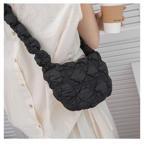 Detail of black puffer shoulder bag with ruched texture and quilted nylon fabric