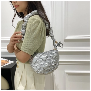 Detail of silver quilted bubble bag with metallic finish and ruffled shoulder strap