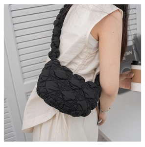 Detail of black quilted puffer shoulder bag with soft textured bubble fabric and strap