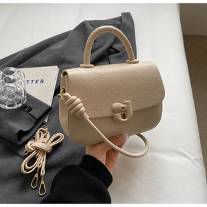 Vue détaillée du sac à main en cuir beige grainé avec poignée ronde et sangle
