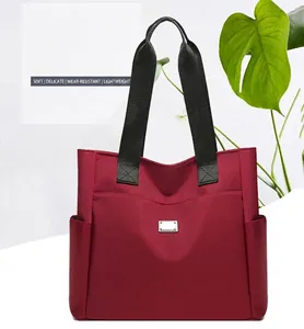 Detail der burgunderroten Oxford-Tasche mit großer Fronttasche und silberner Schnalle
