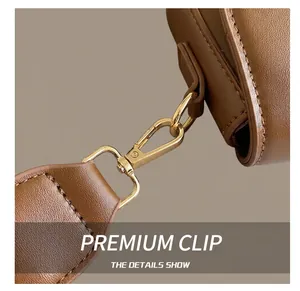 Détails du sac en cuir marron avec boucle métallique en or clair et coutures soignées